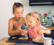 © danr13 - Elder brother taking care of junior sister and helping her drink from the cup during breakfast. Everyday morning moments