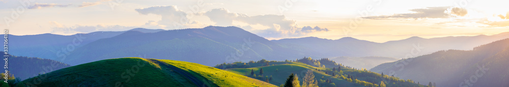 panorama of mountainous countryside in springtime at dusk. path through rolling hills. ridge in the distance. clouds on the sky. beautiful rural landscape of carpathians - obrazy, fototapety, plakaty 