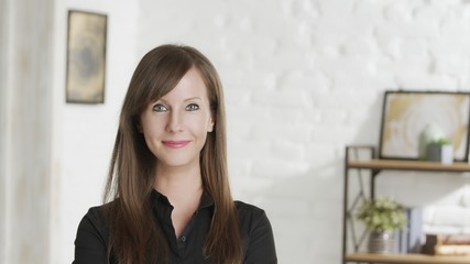 Portrait of confident woman at home, smiling in front of casual home indoor.