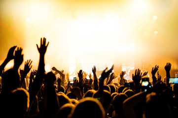 cheerful crowd with raised hands in front of the stage. musical concert of a popular artist. festival banner