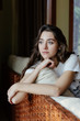 © Sergey Narevskih/Stocksy - Portait of woman sitting on sofa