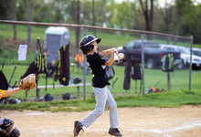 Boy Hitting Baseball During Game