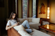 © Sergey Narevskih/Stocksy - Woman sitting on sofa