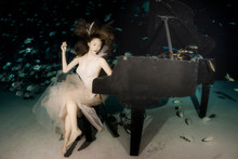 A Female Model Play Piano Underwater