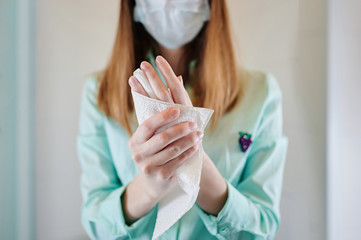 A female doctor wipes her hands on a towel