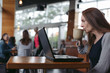 © Rob and Julia Campbell/Stocksy - Mature woman working on laptop at coffee shop