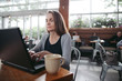 © Rob and Julia Campbell/Stocksy - Mature woman working on laptop at coffee shop