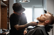 © Milles Studio/Stocksy - Man shaving beard of client in salon chair