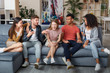 © Kostiantyn - Spending nice time together. Group of young happy multicultural people in casual wear laughing while sitting together on the sofa at home. They relaxing together in the modern apartment