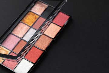 Color professional cosmetic palette on a dark background, close up