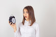 © hbrh - headshot young business woman with alarm clock in hand isolated white grey wall