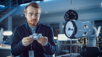 Poster - Electronics Development Engineer Working at His Desk, Fits New Technological Component into Prototype. Professionals Work in the Advanced Technology Designing Agency. Modern Research Centre 
