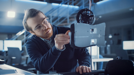 Poster - Electronics Development Engineer Working at His Desk, Fits New Technological Component into Prototype. Professionals Work in the Advanced Technology Designing Agency. Modern Research Centre 