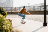 Skateboarding at city. Female, enjoyment. Hipster girl riding skate board. Ride, style. Extreme sport and emotions concept. Alternative lifestyle. Woman skateboarder skateboarding at city