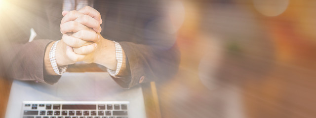 A man praying by faith with computer laptop ,Church services online concept, Online church at home concept, spirituality and religion.