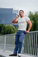 Wall Mural - Sports guy stands and talks on the phone. Lifestyle