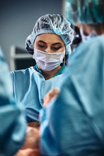 In The Hospital Operating Room. An International Team Of Professional Surgeons And Assistants Works In A Modern Operating Room. Professional Doctors Celebrate Successfully Saved Lives.