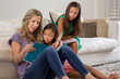 © digitalskillet1 - Mother Reading To Her Daughters And Helping Them With Their Homework