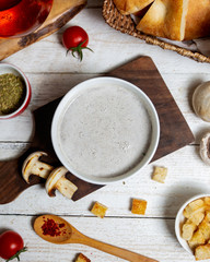 Canvas Print - top view of mushroom soup served on wooden board