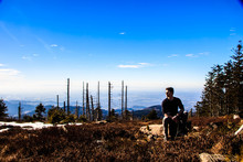 Man Sitting On Rock Against Sky During Sunny Day