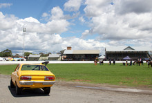 Yellow Retro Race Car At The Showground With Horses In The Background 