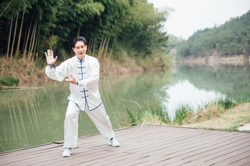 Asian aged man tai chi at the lake