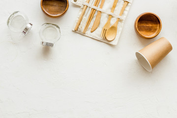 Wall Mural - Paper glass, glass jar, wooden tableware on white desk, top view. Eco friendly packaging for take away copy space