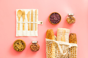 Wall Mural - Glass jars, cotton bags on pink background, top view. Eco friendly concept for kitchen - food storage