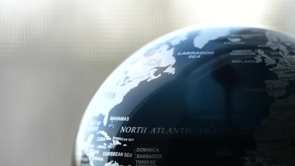 Wall Mural - Loop able Earth globe slowly spinning on a desk next too a window on a sunny day. 