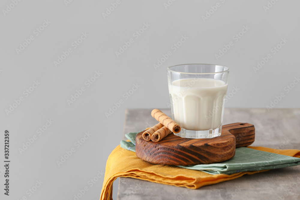Glass of milk on table against grey background