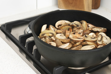 Wall Mural - Chopped champignon mushrooms frying in pan