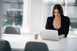 © JustLife - Young businesswoman working on lap top. Beautiful woman in office.