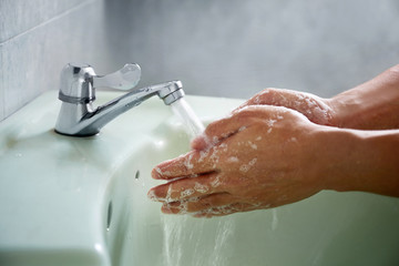 Washing of hands with soap under the crane with water