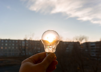 incandescent light bulb on the background of the sun 