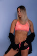 © Inception - Sports muscular woman portrait wearing black sportswear over grey. Attractive sexy caucasian woman with long blond hair in studio shot.