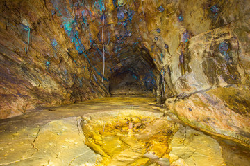 Abandoned copper ore mine underground tunnel with yellow dirt