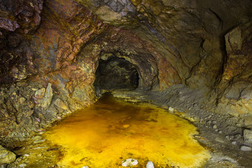 Abandoned copper ore mine underground tunnel with yellow dirt