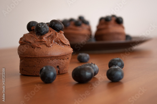 Cuadros en Lienzo Czekoladowe muffiny z jagodami na drewnianym stole.
