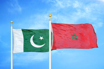 Pakistan and Morocco two flags on flagpoles and blue cloudy sky