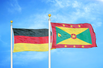 Germany and Grenada two flags on flagpoles and blue cloudy sky