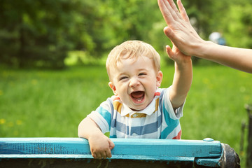 outdoor portrait of a boy on green background. happy child on walking in summer park.