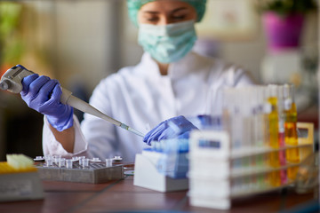 Female in lab using pipette for analysis