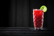 raspberry cocktail on black wooden bar with black background
