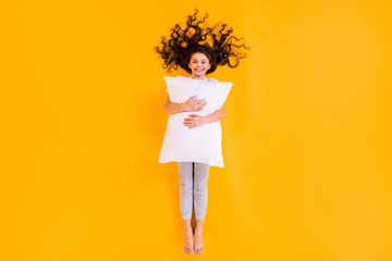 Poster - Full length high angle above flat lay view photo of beautiful little lady lying floor morning hold hug white pillow comfy wear pajama pants t-shirt isolated yellow color background