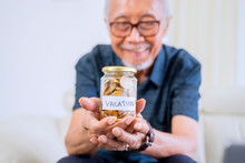 Old Man Shows A Jar With Coins And Vacation Text