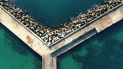 Wall Mural - Bridge with stones in deep sea water, aerial view