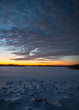 Sunset colors and cloud formations over a frozen wetland habitat in the Midwest.
