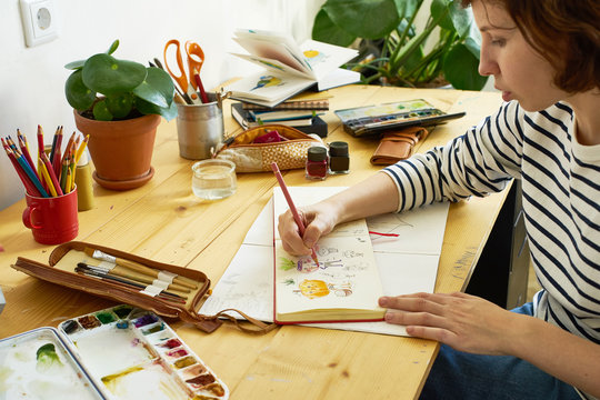 close-up image of artist drawing in a sketchbook. female designer working from home. creative cozy w