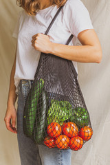 Wall Mural - Girl holding mesh shopping bag with vegetables. Sustainable, zero waste and plastic free lifestyle.