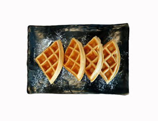 Waffles on black dish or plate isolated on white background with clipping path or make selection. Fresh bakery baked and Dessert food concept